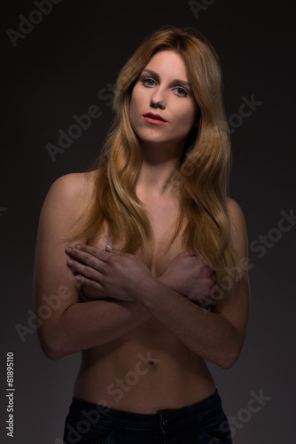 Topless woman covering breast