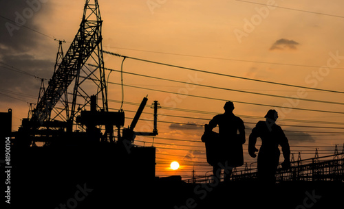 Silhouette of engineer looking at blueprints in a building site