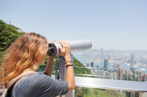 girl looking through a telescope at the Hong Kong from Victoria