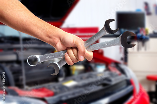 Hand of car mechanic with wrench.