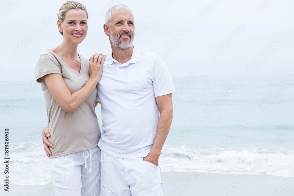 Happy couple hugging each other by the sea