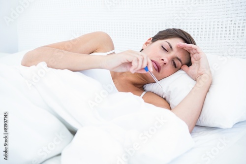 Sick woman looking at her thermometer