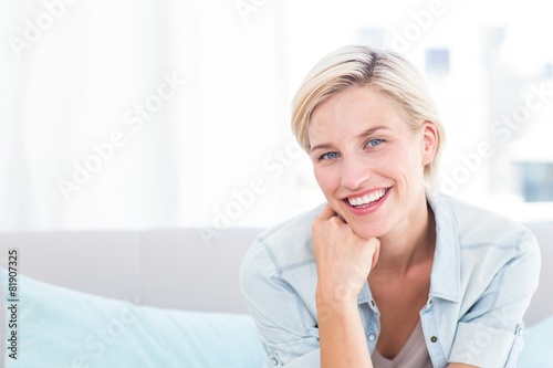 Φωτογραφία Pretty blonde woman sitting on the couch and smiling
