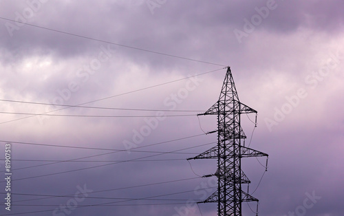 High voltage power pylon on a cloudy sky at sunset