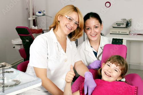 little girl patient with thumb up in dental office