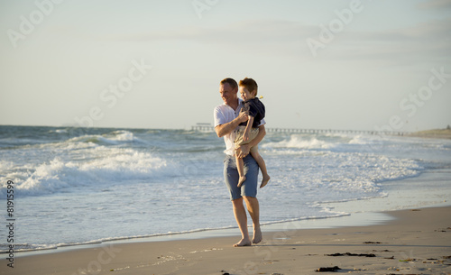 young happy father holding little son walking on beach holidays