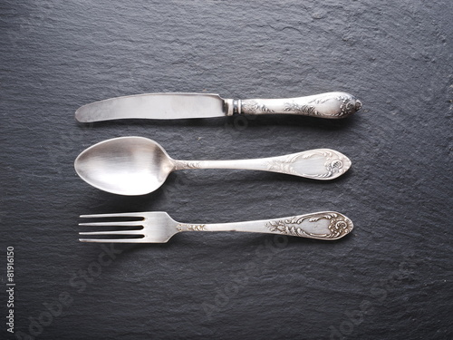 Silver cutlery on a dark grey background. photo