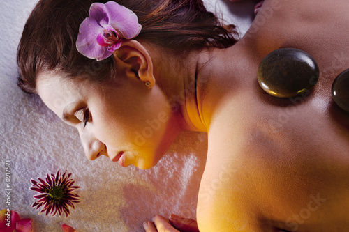 Fotografie Young woman getting stone massage procedure.