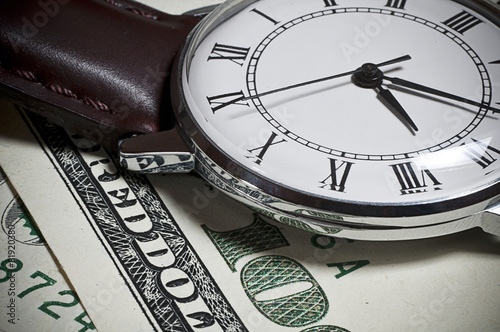 Closeup of old watch on one houndred dollar bill