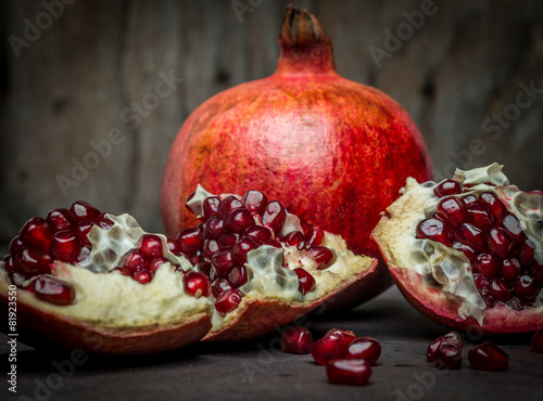 Some red juicy pomegranate, whole and broken photo