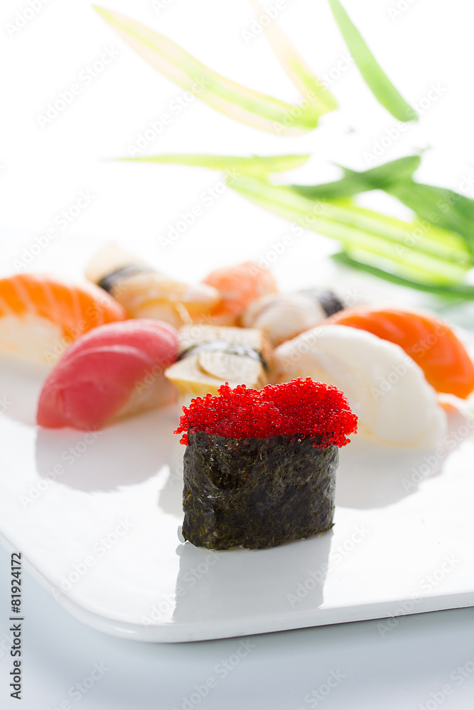 Sushi gunkan with red tobiko and nigiri on a white plate Sushi gunkan with red tobiko and nigiri on a white plate