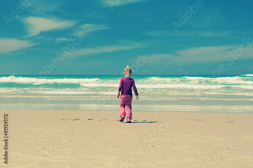 4 years old girl playing on the beach