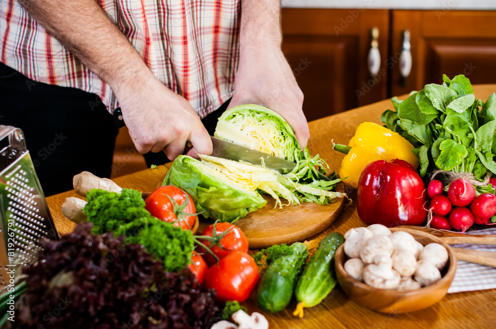 Man cuts fresh spring vegetables