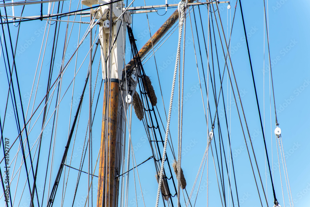 sailboat masts, rigging and rolled up sails sailboat masts, rigging and rolled up sails