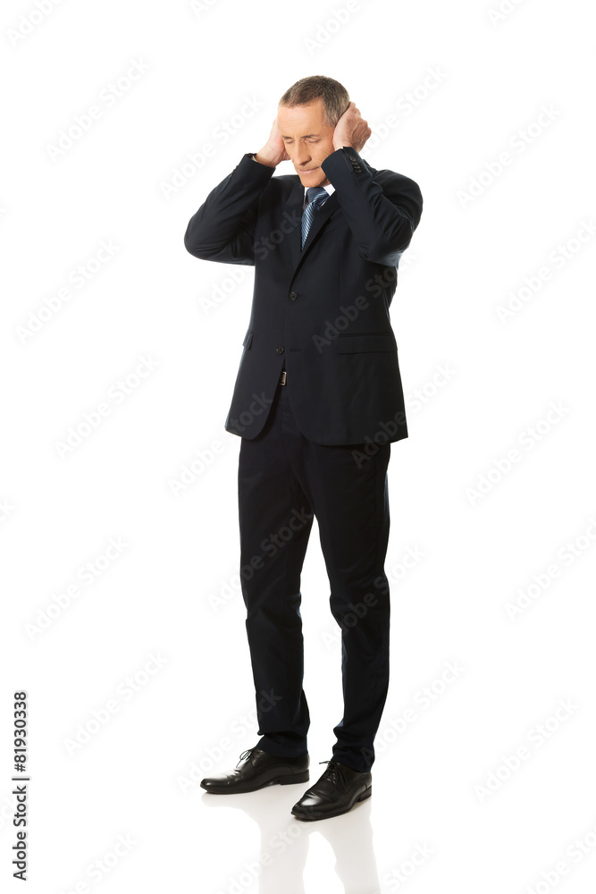 Tired man covering ears with hands Tired man covering ears with hands