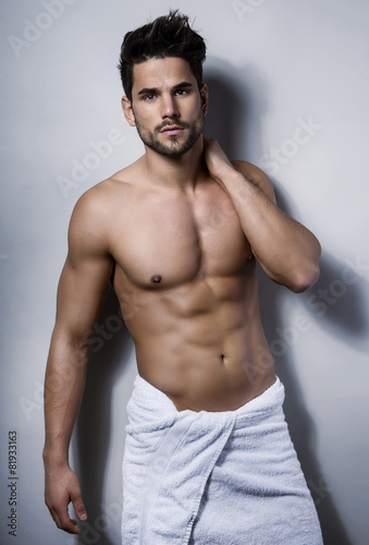 handsome young bodybuilder showing of his fit body and muscles