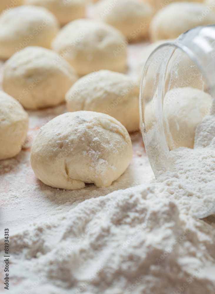 balls of dough covered with wheat flour ready for baking