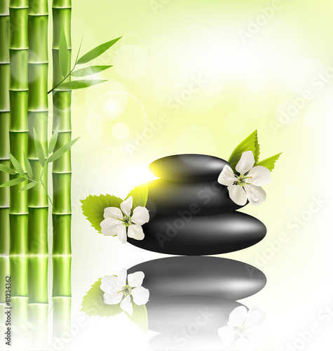 Stack of spa stones with cherry white flowers sunlight and bambo