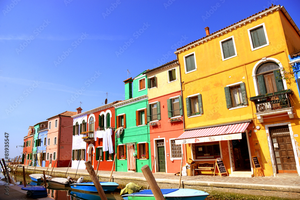 Burano island canal, colorful houses and boats, Italy