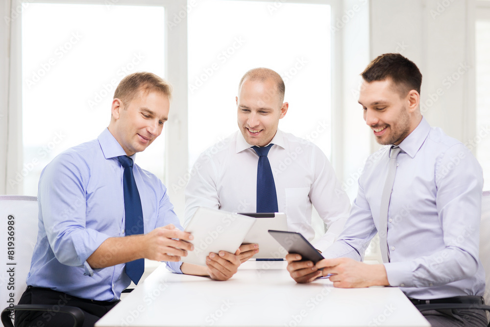 three smiling businessmen with tablet pc in office three smiling businessmen with tablet pc in office