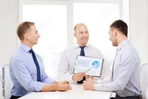smiling businessmen with papers in office
