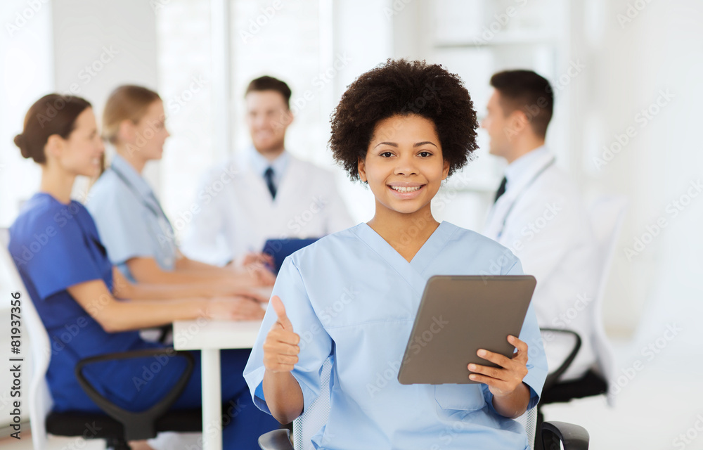 happy doctor with tablet pc over team at clinic happy doctor with tablet pc over team at clinic