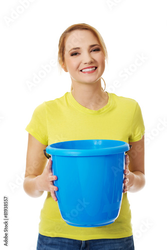Young woman holding blue bucket.