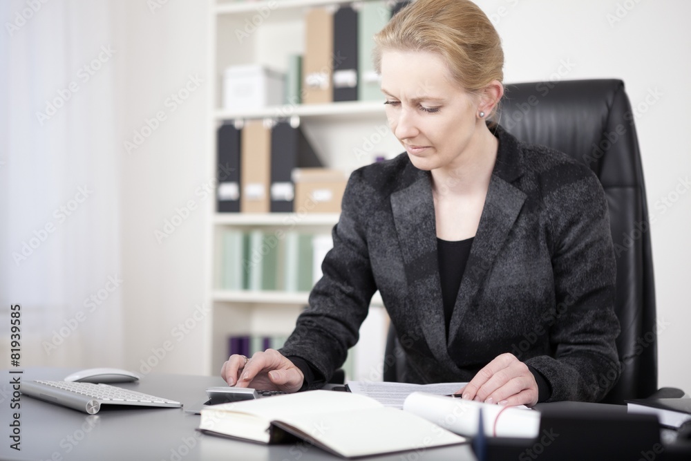 Office Woman Sitting at her Desk Calculating Sales Office Woman Sitting at her Desk Calculating Sales