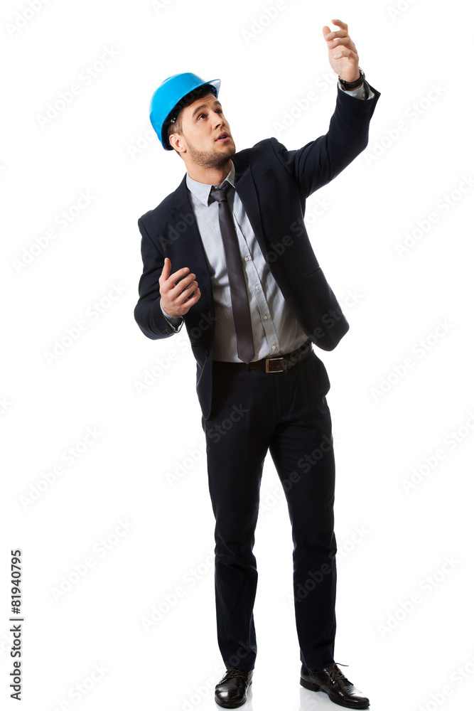 Businessman in hard hat showing copyspace. Businessman in hard hat showing copyspace.