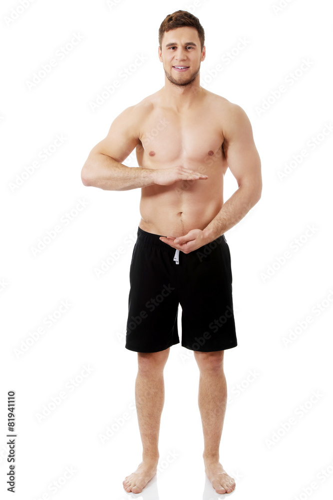 Sexy muscular man holding copyspace in hands.