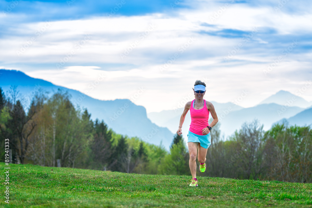 Obraz premium Blonde girl athlete runs in the mountains