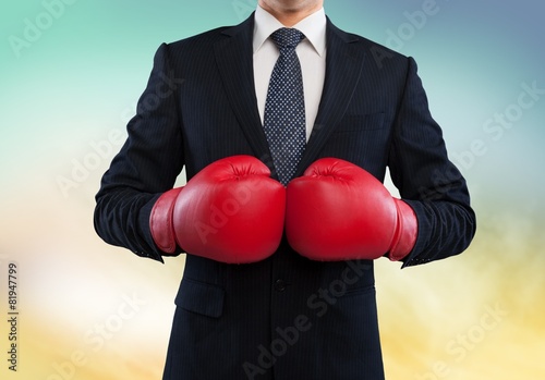 Boxing. Businessman in boxing gloves on background © BillionPhotos.com