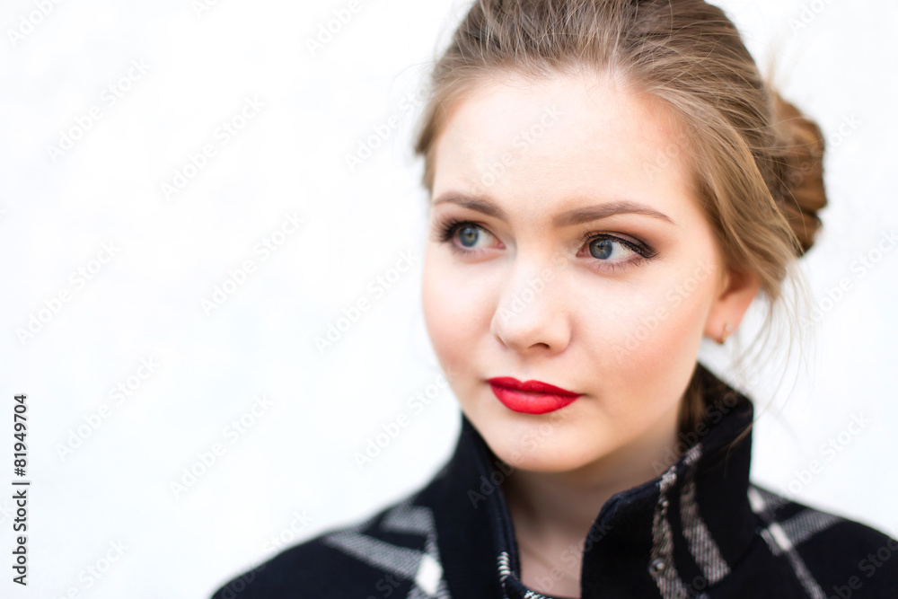 Fototapeta premium portrait of a beautiful girl in high key against a white wall