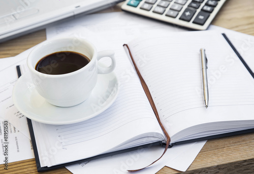Coffee Cup at Office with Financial Papers,Agenda and Calculator