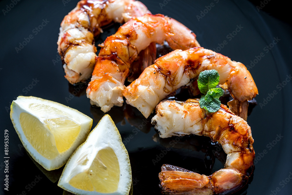 Fried shrimps with lemon wedges on the black background Fried shrimps with lemon wedges on the black background