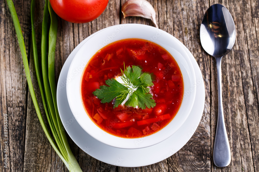 Borsch with bread on a wooden background.