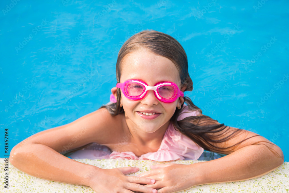 Smiling happy girl in goggles for swimming at outdoor pool