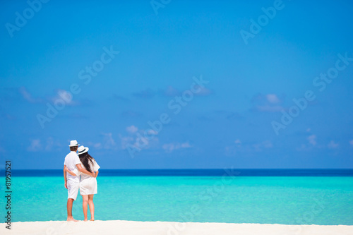 Back view of young couple on white beach at summer vacation