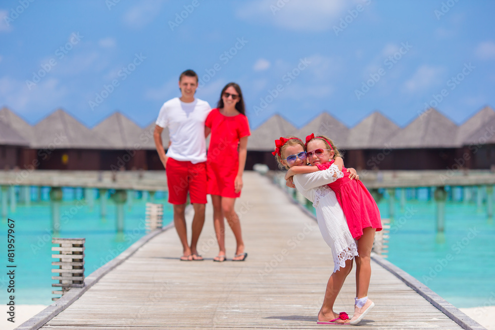 Happy beautiful family on wooden jetty during summer vacation at