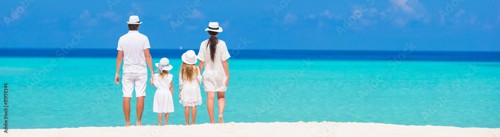 Rear view of young beautiful family on white tropical beach Rear view of young beautiful family on white tropical beach