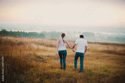 Beautiful couple  comes in a field at sunset  lifestyle-concept