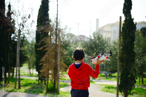 Boy playing with airplanes resque team in the park