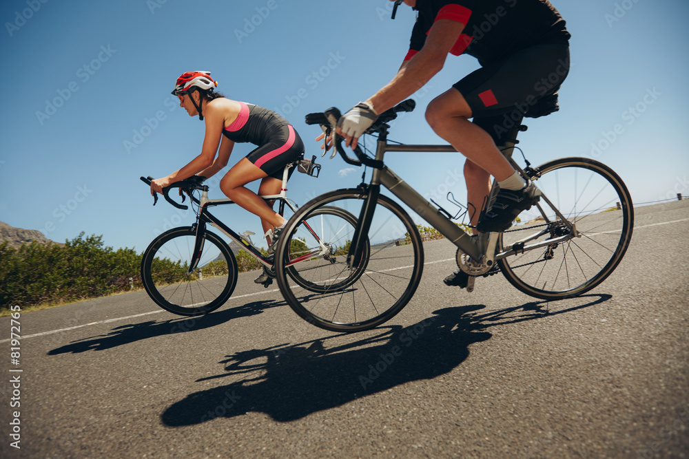 Cyclist riding bicycles down hill on country road Cyclist riding bicycles down hill on country road