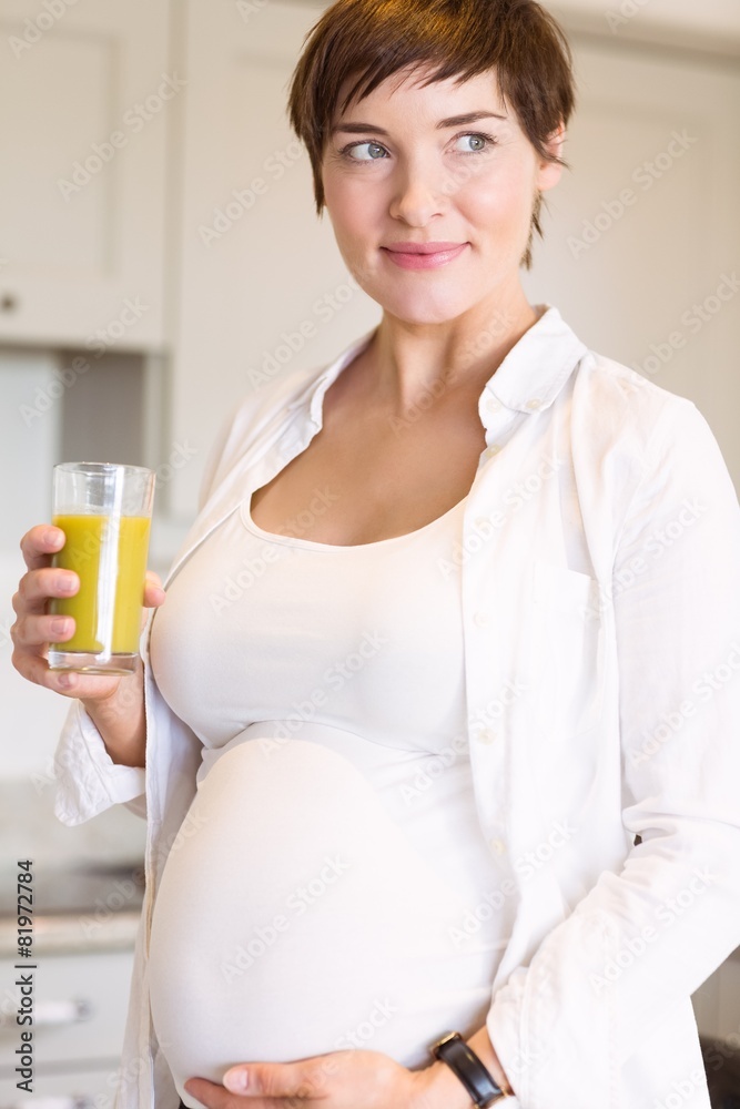 Pregnant woman having a glass of orange juice Pregnant woman having a glass of orange juice