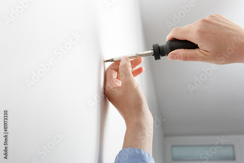 Obraz na płótnie Worker manually tightening hang screw w salonie
