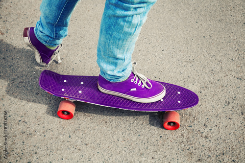 Skateboarder in jeans, feet fragment with skate