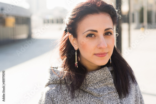 Beauty portrait of young adult woman in city. Urban scene.