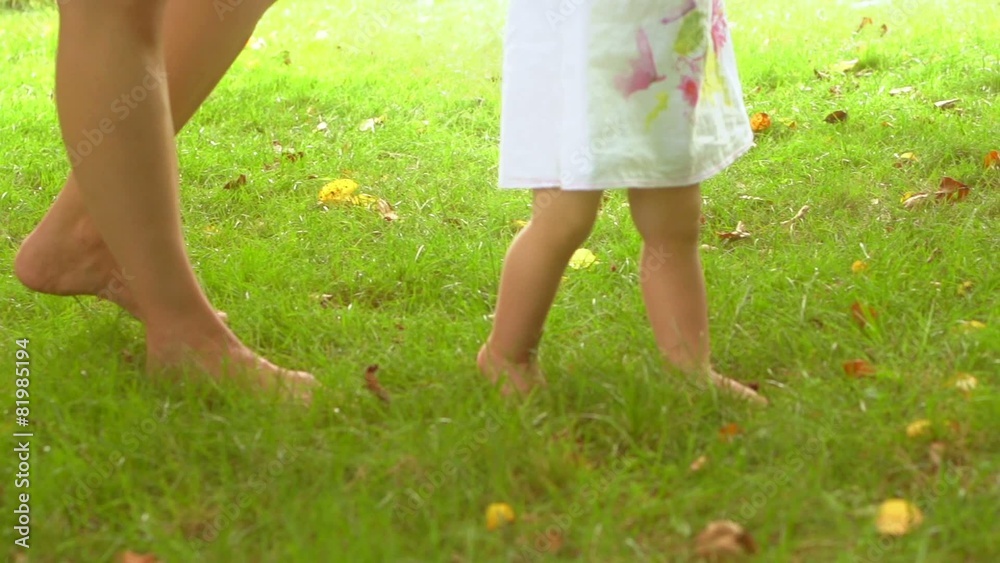 Adorable one year old baby girl making her first steps Adorable one year old baby girl making her first steps