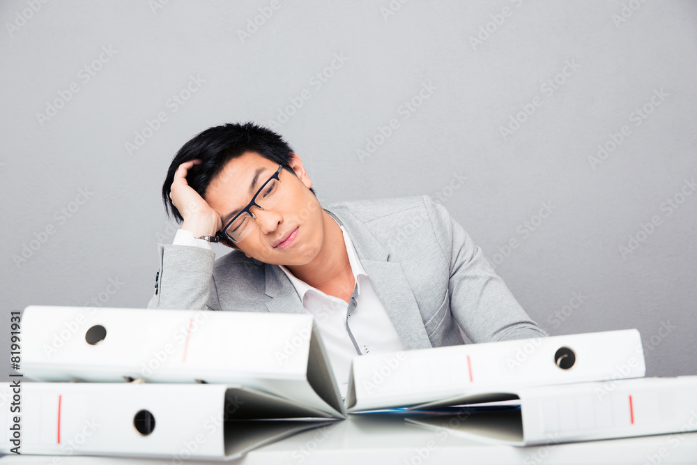Fototapeta premium Tired young businessman sitting at the table