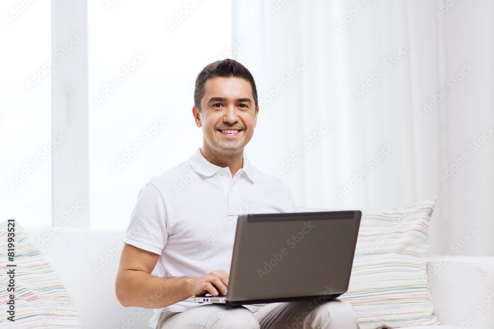 happy man working with laptop computer at home